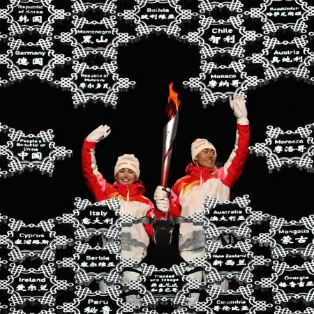 Chinese torchbearer athletes Dinigeer Yilamujian (L) and Zhao Jiawen wave with the Olympic flame in the middle of a giant snowflake during the opening ceremony of the Beijing 2022 Winter Olympic Games, at the National Stadium, known as the Bird's Nest, in Beijing, on February 4, 2022. - Dinigeer Yilamujiang is a cross-country skier and Zhao Jiawen a nordic combined athlete, and both are members of the Chinese team participating in the current Games. (Photo by Manan VATSYAYANA / AFP) (Photo by MANAN VATSYAYANA/AFP via Getty Images)