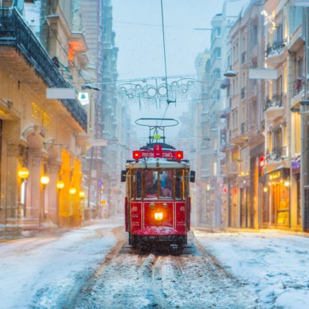 ISTANBUL, TURKEY - JANUARY 7, 2017: Snowy day in Taksim, Beyoglu. Nostalgic tram in Istiklal Street. Taksim Istiklal Street is a popular destination in Istanbul, Turkey.